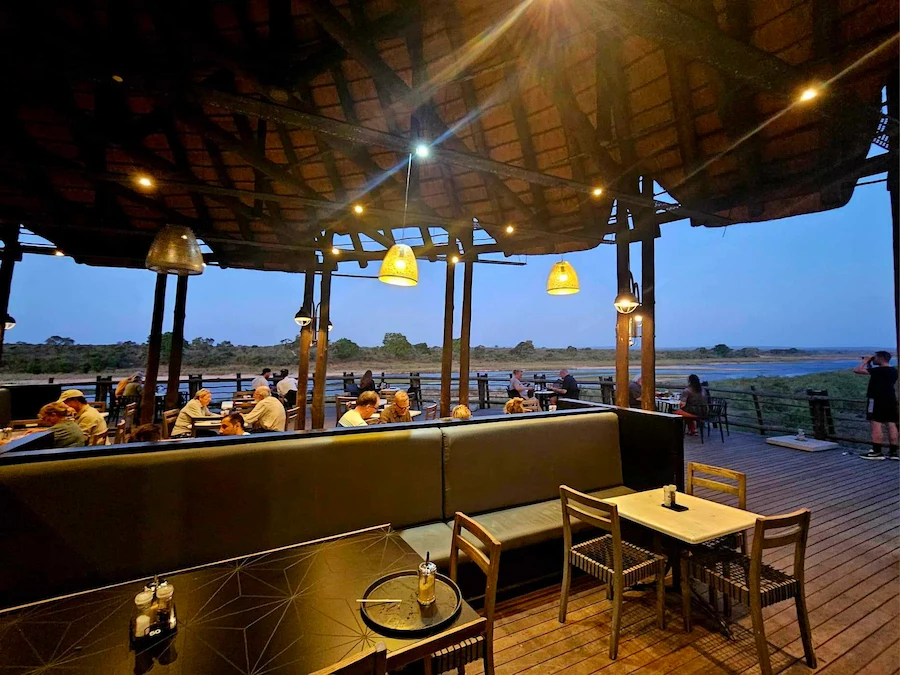Evening scene of visitors eating by the river at Lower Sabie Rest Camp in Kruger National Park.